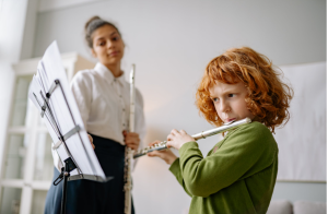 Woman teaching child to play the flute.