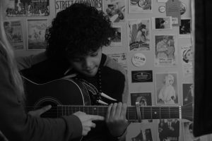 a kid taking guitar lessons.