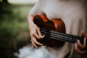 a woman playing ukulele in the outdoors