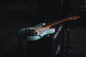 a teal and brown electric guitar on an amplifier