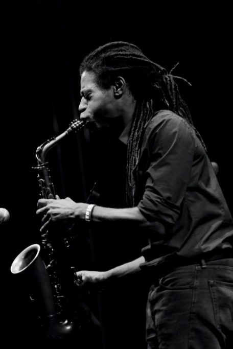 A monochrome photo of a man playing the saxophone.