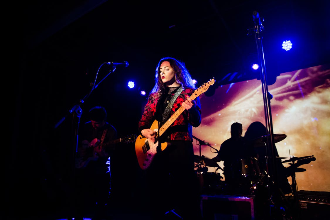 A woman playing the electric guitar on stage