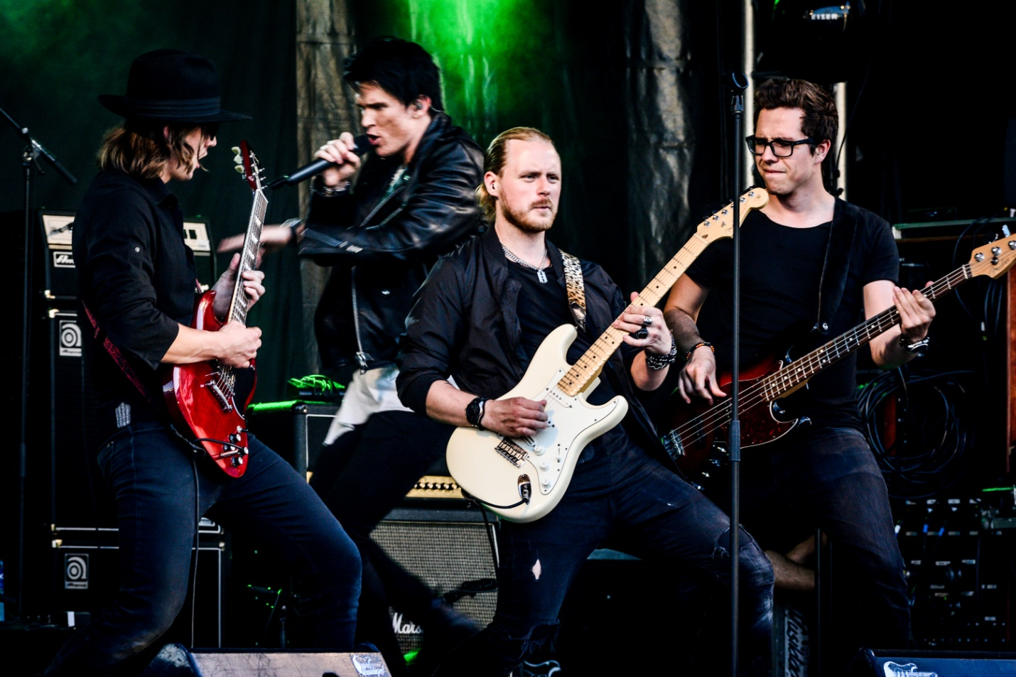 A band of four men performing on a stage