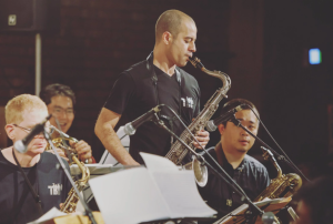 Man playing saxophone with band.